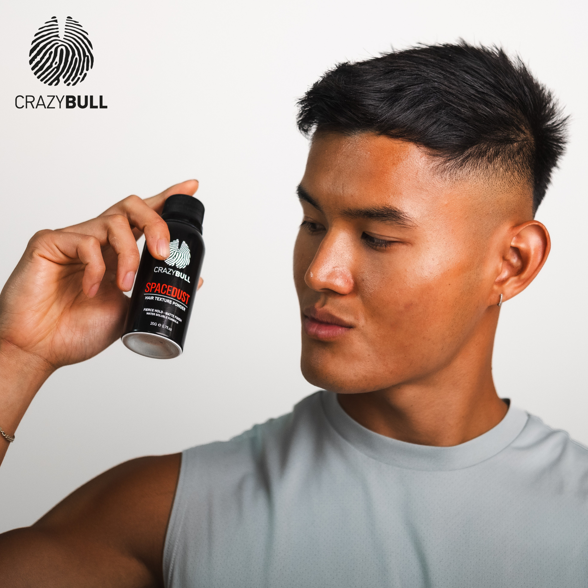 Person holding a bottle of Crazy Bull Space Dust hair texture powder